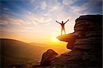 A person expressing freedom - reaching up into the sky against a sunset.