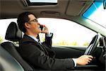 businessman driving and talking on the phone
