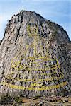 Carved buddha image from gold on the cliff at Khao Chee Jan, Pattaya, Thailand