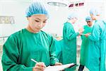 woman Surgeons writing medical record with teams