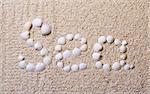 Title "Sea" from shells with coral sand as background