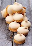 Heap of Swirled Meringue Topping with Biscuit Bottom isolated on Rustic Wooden background