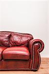 Luxurious Red Leather Couch Detail in front of a blank wall to ad your text, logo, images, etc.
