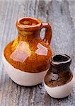 Two Little Handmade Earthenware Jugs isolated on Rustic Wooden background