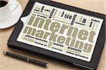 internet marketing - word cloud on a digital tablet with a cup of coffee