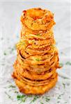 Homemade crunchy fried onion rings on a parchment. Focus on top rings