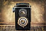 Old fashioned antique camera in vintage style with filtered textured background