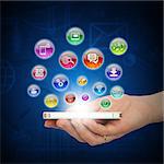 Hand holding smartphone and application icons. The concept of software