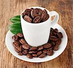 Coffee beans with leaf on wooden tables. Coffee drinks.