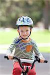 cute smiling boy in helmet riding a bike