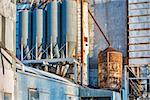industrial background - exterior of old grain elevator with pipes, ducts, ladders and chutes