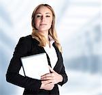 Smart business woman holding in hands laptop and standing in the office, work in great finance company, executive manager, good job concept