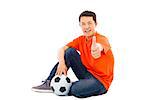 young man sitting with a soccer and thumb up