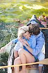 Young romantic couple fooling around in rowing boat