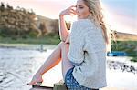 Young woman sitting on pier