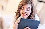 Young woman lying in bed with digital tablet