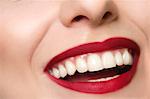 Cropped studio portrait of young woman's smiling mouth