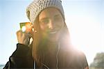 Portrait of young woman wearing earphones listening to music