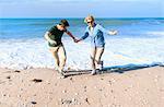 Mid adult couple fooling around on beach, Thurlestone, Devon, UK