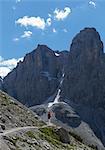 Climber approaching rocky peak, Brenta Dolomites, Italy