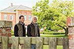 Father and son in garden with house in background