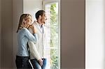 Portrait of mid adult couple looking out of window