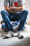 Man sitting on top of full suitcase