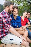 Portrait of four friends sitting on fence, Tyrol Austria