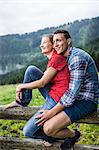 Portrait of couple sitting on fence, Tyrol Austria