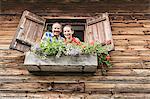 Portrait of couple at chalet window, Achenkirch,  Tyrol, Austria