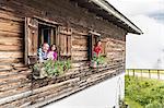 Portrait of family at chalet windows, Achenkirch,  Tyrol, Austria