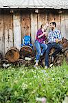 Couple sitting on cut logs having wine