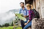 Couple with map embarking on trek, Tirol, Austria