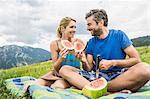 Couple eating watermelon at picnic