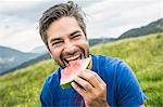 Man biting into watermelon