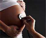 Stethoscope on pregnant woman's belly