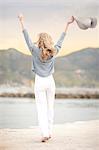 Woman stretching with hat in hand, Hout Bay, Cape Town, South Africa