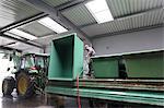 Worker cleaning containers in industrial wine cellar