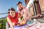 Young couple with apples outside chalet, Tyrol, Austria