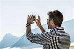 Man photographing view on his mobile phone, Tyrol, Austria