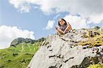 Young girl sitting on rocks, Tyrol, Austria