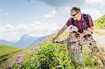 Father and daughter looking at plants, Tyrol, Austria