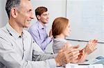 Business colleagues clapping in meeting