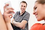 Young adult couple looking at mobile phone