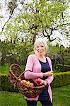 Portrait of mature woman with basket of apples