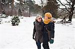 Mother and daughter walking in snow