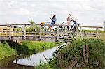 Family cycling over wood bridge