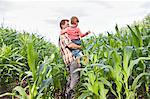 Farmer and son in field of crops