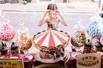 Girl looking through window of sweet shop