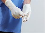 Surgeon putting on latex gloves